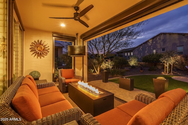 patio terrace at dusk with an outdoor living space with a fire pit and ceiling fan