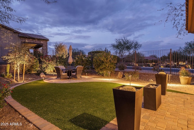 yard at dusk featuring a patio area