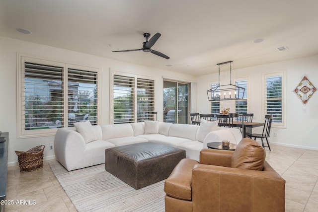 living room featuring ceiling fan with notable chandelier