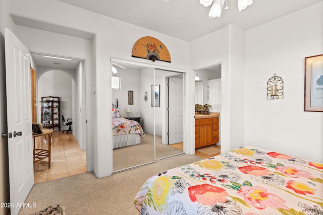 carpeted bedroom featuring ceiling fan and a closet