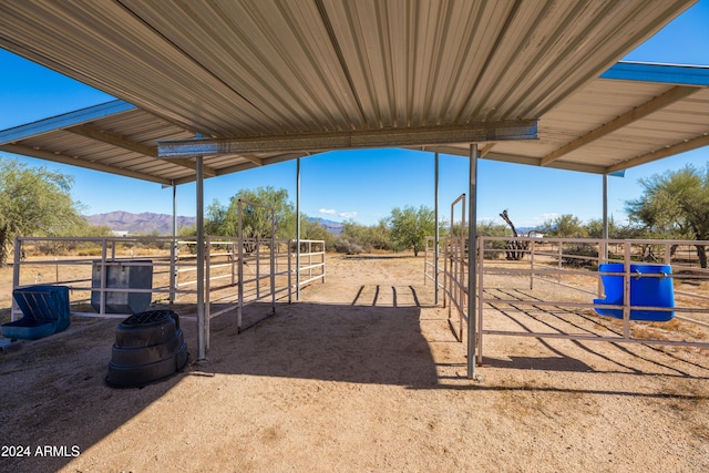 view of horse barn featuring a mountain view and a rural view