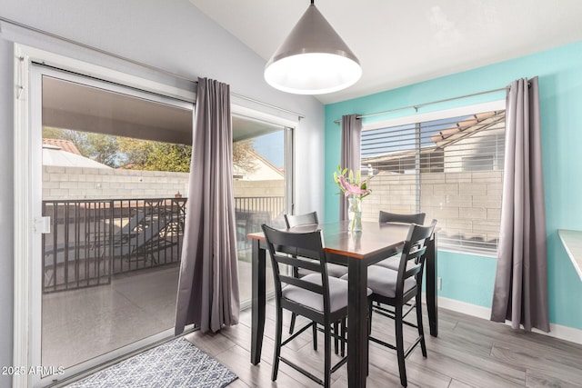 dining area with lofted ceiling and hardwood / wood-style floors