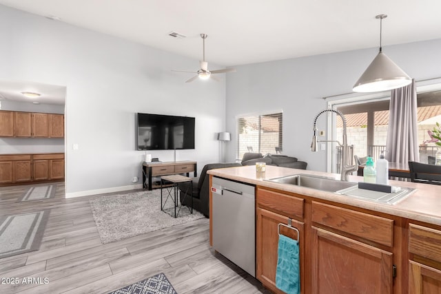 kitchen with sink, light hardwood / wood-style flooring, ceiling fan, decorative light fixtures, and stainless steel dishwasher