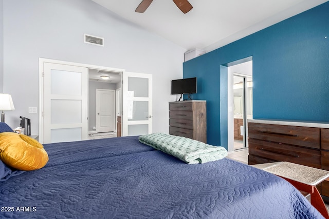 bedroom with light tile patterned floors, high vaulted ceiling, ceiling fan, and ensuite bathroom