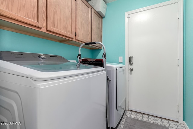 laundry area with washing machine and dryer and cabinets