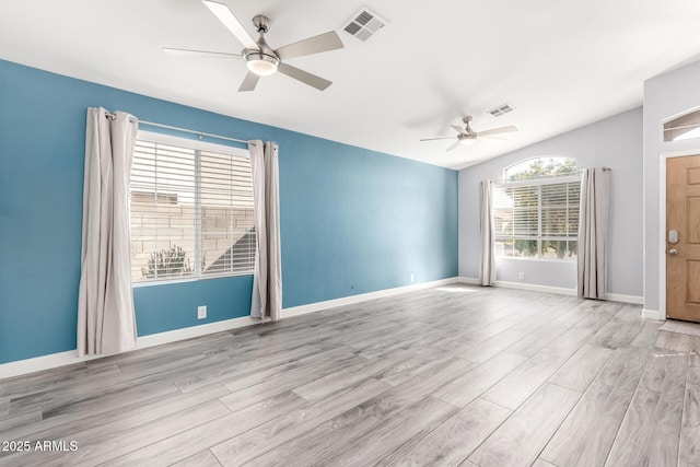 empty room featuring ceiling fan, lofted ceiling, and light hardwood / wood-style floors