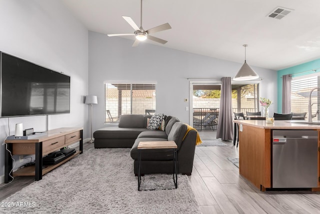 living room featuring sink, high vaulted ceiling, ceiling fan, and light wood-type flooring