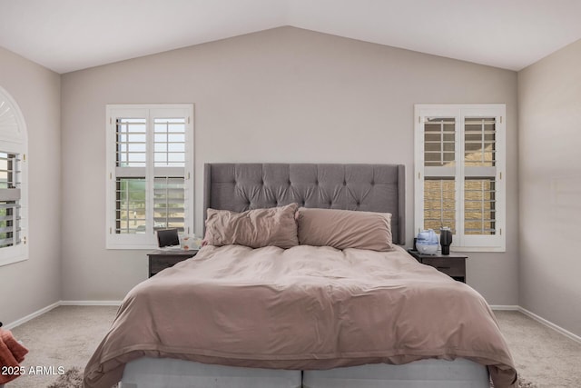 bedroom with vaulted ceiling, baseboards, and carpet