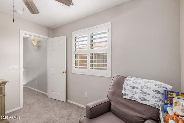 living area with a ceiling fan, baseboards, and carpet