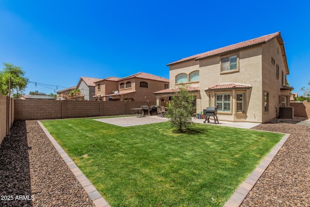 rear view of house featuring a fenced backyard, a tiled roof, and stucco siding