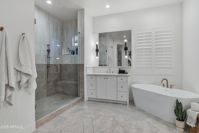 bathroom with vanity and shower with separate bathtub