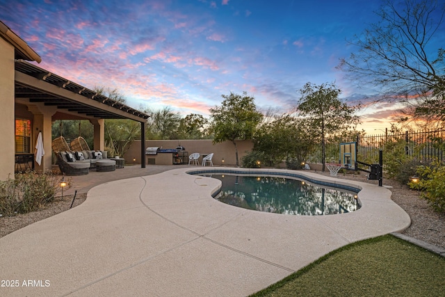 pool at dusk featuring an outdoor living space and a patio area