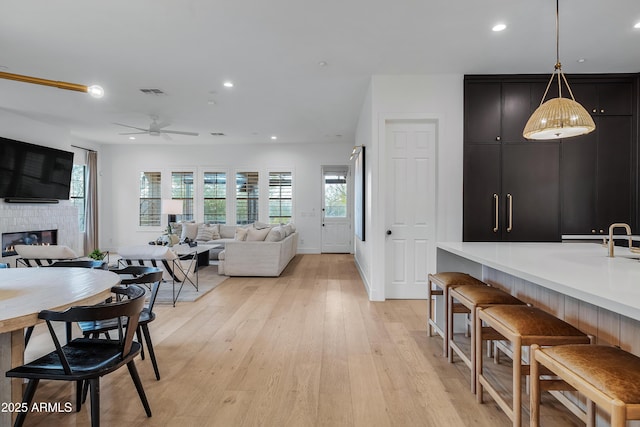 interior space with a fireplace, light hardwood / wood-style floors, and ceiling fan