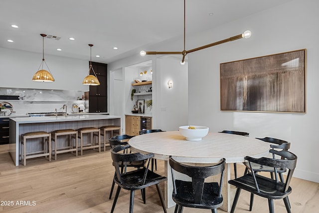 dining space featuring sink and light hardwood / wood-style flooring