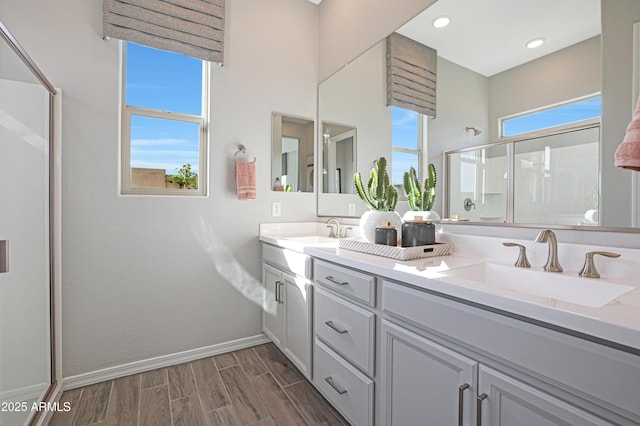 bathroom with an enclosed shower, hardwood / wood-style floors, vanity, and a wealth of natural light