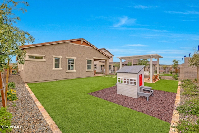 rear view of house with a yard and an outbuilding
