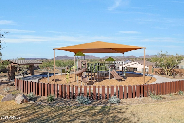 wooden deck with a playground and a mountain view