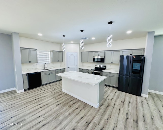 kitchen featuring a kitchen island, a sink, gray cabinetry, and black appliances