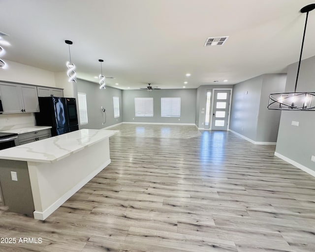 kitchen featuring open floor plan, visible vents, baseboards, freestanding refrigerator, and recessed lighting