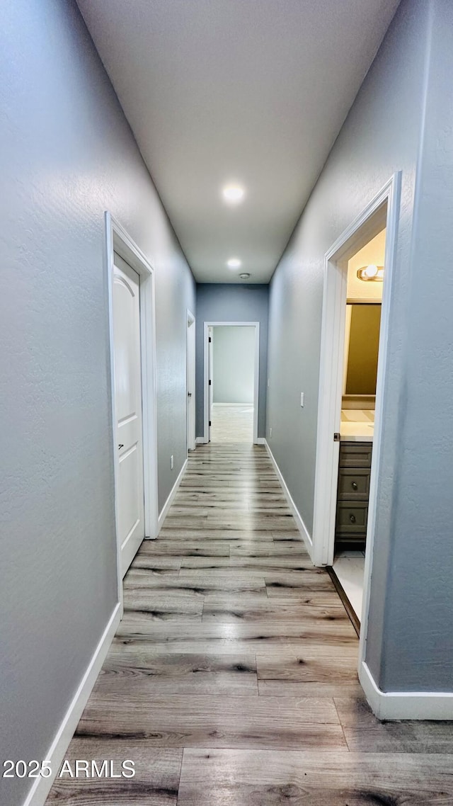 hall with wood finished floors and baseboards