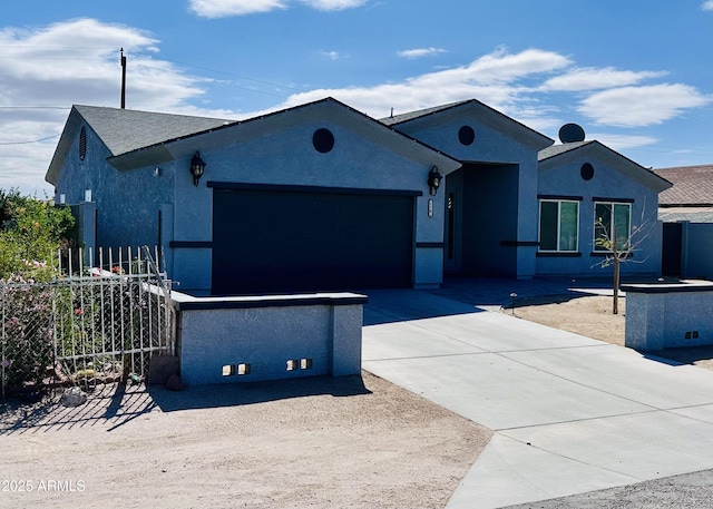 ranch-style house featuring an attached garage, stucco siding, fence, and concrete driveway