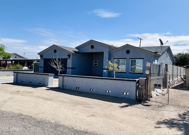 view of front facade with stucco siding and fence