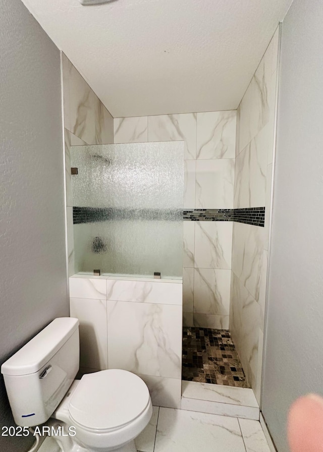 bathroom featuring walk in shower, marble finish floor, and toilet