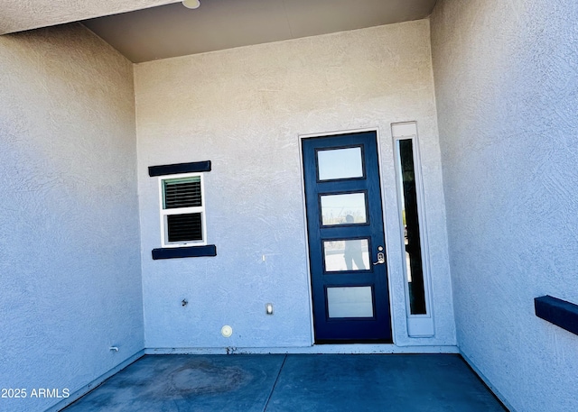 view of exterior entry featuring stucco siding
