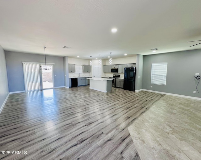 unfurnished living room featuring recessed lighting, light wood-style floors, visible vents, and baseboards
