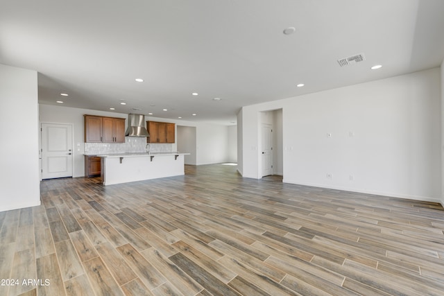 unfurnished living room featuring light hardwood / wood-style flooring and sink