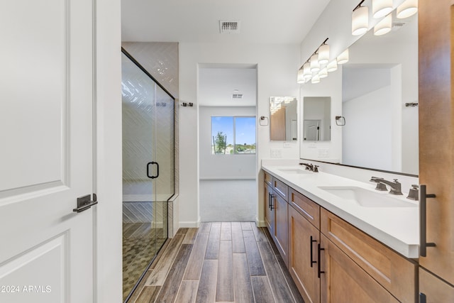 bathroom featuring vanity, hardwood / wood-style floors, and a shower with shower door