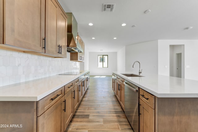 kitchen featuring black electric cooktop, light wood-type flooring, stainless steel dishwasher, sink, and a spacious island