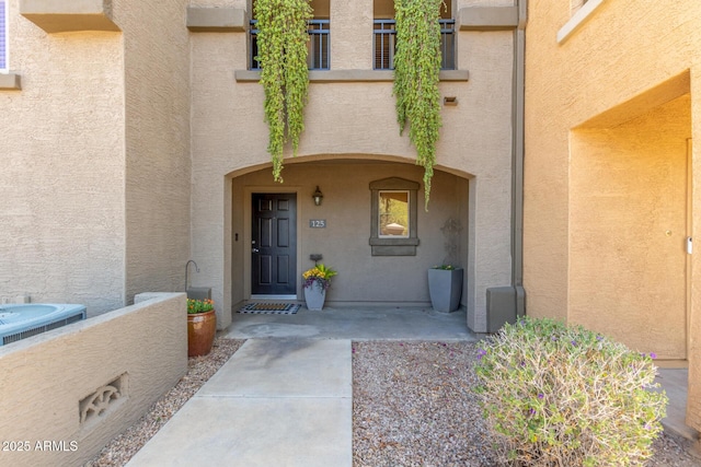 property entrance featuring central AC unit and stucco siding