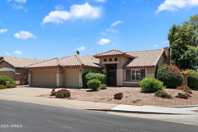 4223 E Danbury Rd, Phoenix, AZ 85032 - mediterranean / spanish-style house featuring a tiled roof, stucco siding, an attached garage, and concrete driveway