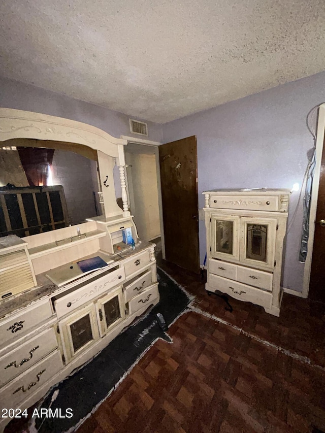 kitchen with dark parquet floors and a textured ceiling