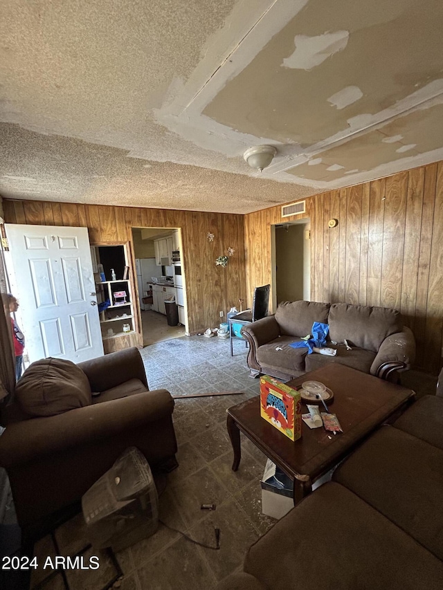 living room featuring wood walls and a textured ceiling