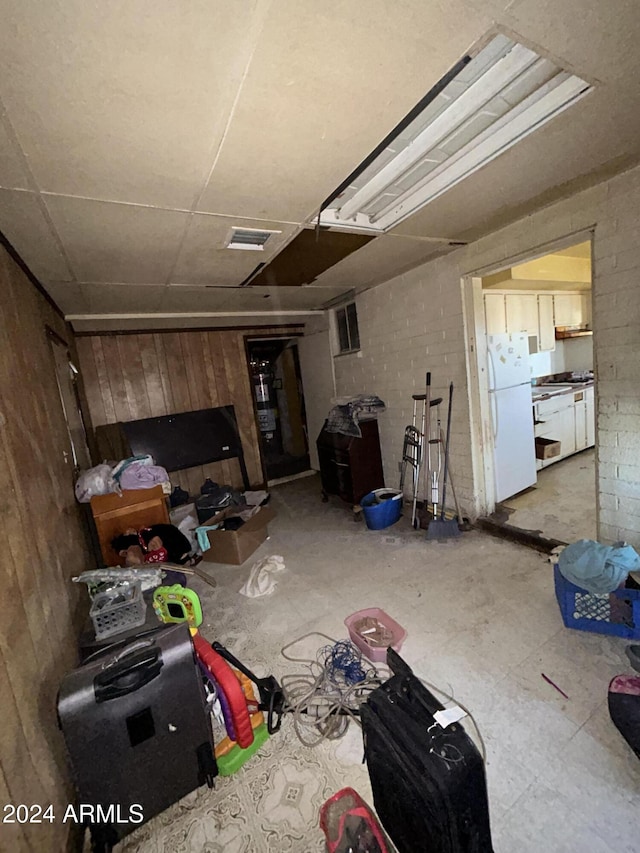 interior space featuring white fridge and wooden walls