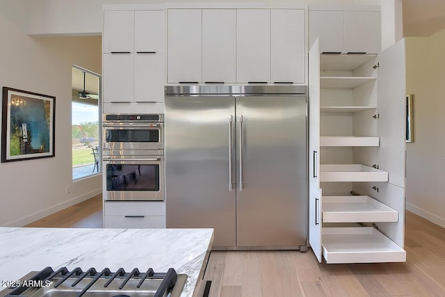 12225 E Cortez Dr, Scottsdale, AZ 85259 - kitchen featuring white cabinetry, open shelves, appliances with stainless steel finishes, and light wood-style floors
