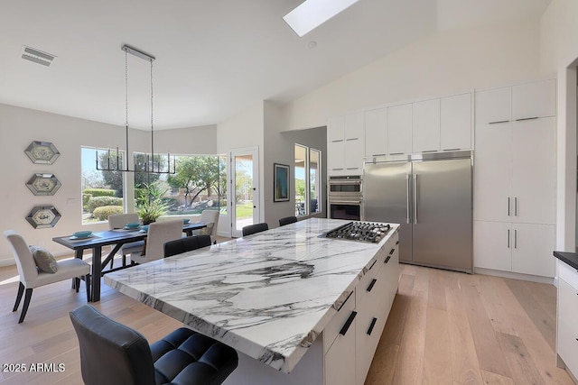 12225 E Cortez Dr, Scottsdale, AZ 85259 - kitchen with modern cabinets, light wood-type flooring, white cabinets, visible vents, and appliances with stainless steel finishes