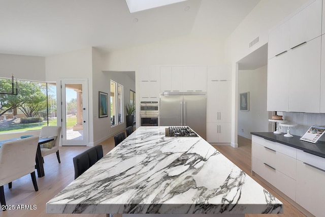 12225 E Cortez Dr, Scottsdale, AZ 85259 - kitchen with modern cabinets, visible vents, high vaulted ceiling, and stainless steel appliances