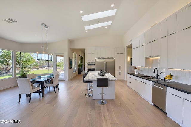 12225 E Cortez Dr, Scottsdale, AZ 85259 - kitchen featuring modern cabinets, a kitchen bar, tasteful backsplash, a sink, and stainless steel appliances