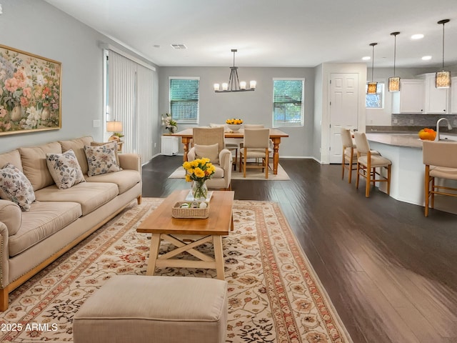 living room featuring hardwood / wood-style flooring, a notable chandelier, and sink