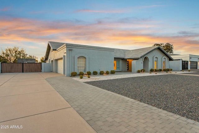 view of front facade featuring a garage, driveway, and stucco siding