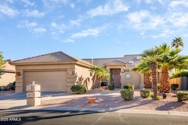 view of front facade with driveway, an attached garage, a tiled roof, and stucco siding