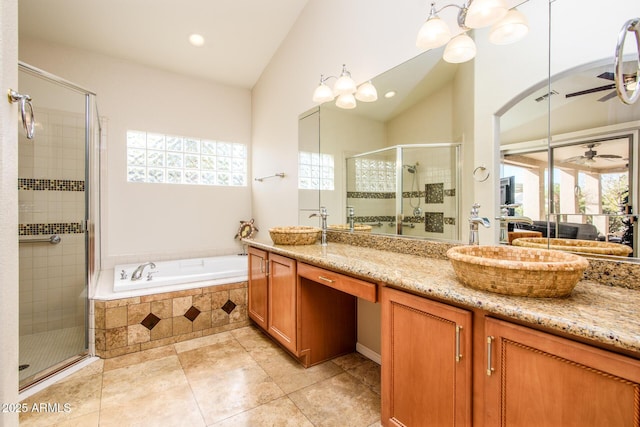 bathroom with ceiling fan, vaulted ceiling, a shower stall, a bath, and double vanity