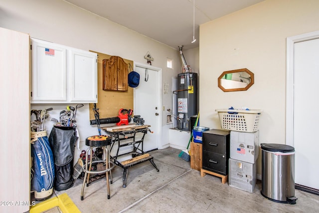 kitchen featuring white cabinets, water heater, and concrete floors