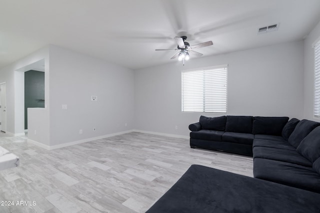 living room with ceiling fan and light hardwood / wood-style flooring