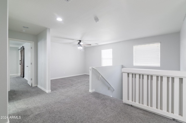 hall with a barn door and carpet