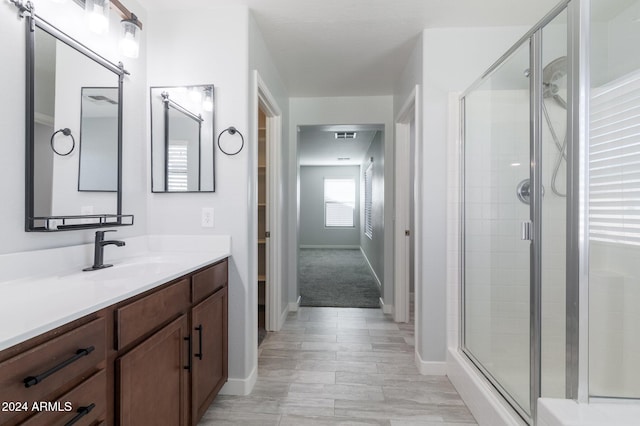 bathroom with wood-type flooring, vanity, and an enclosed shower