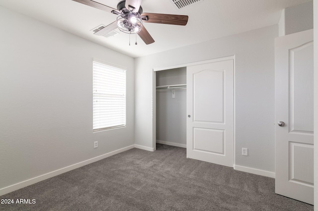 unfurnished bedroom featuring a closet, dark carpet, and ceiling fan